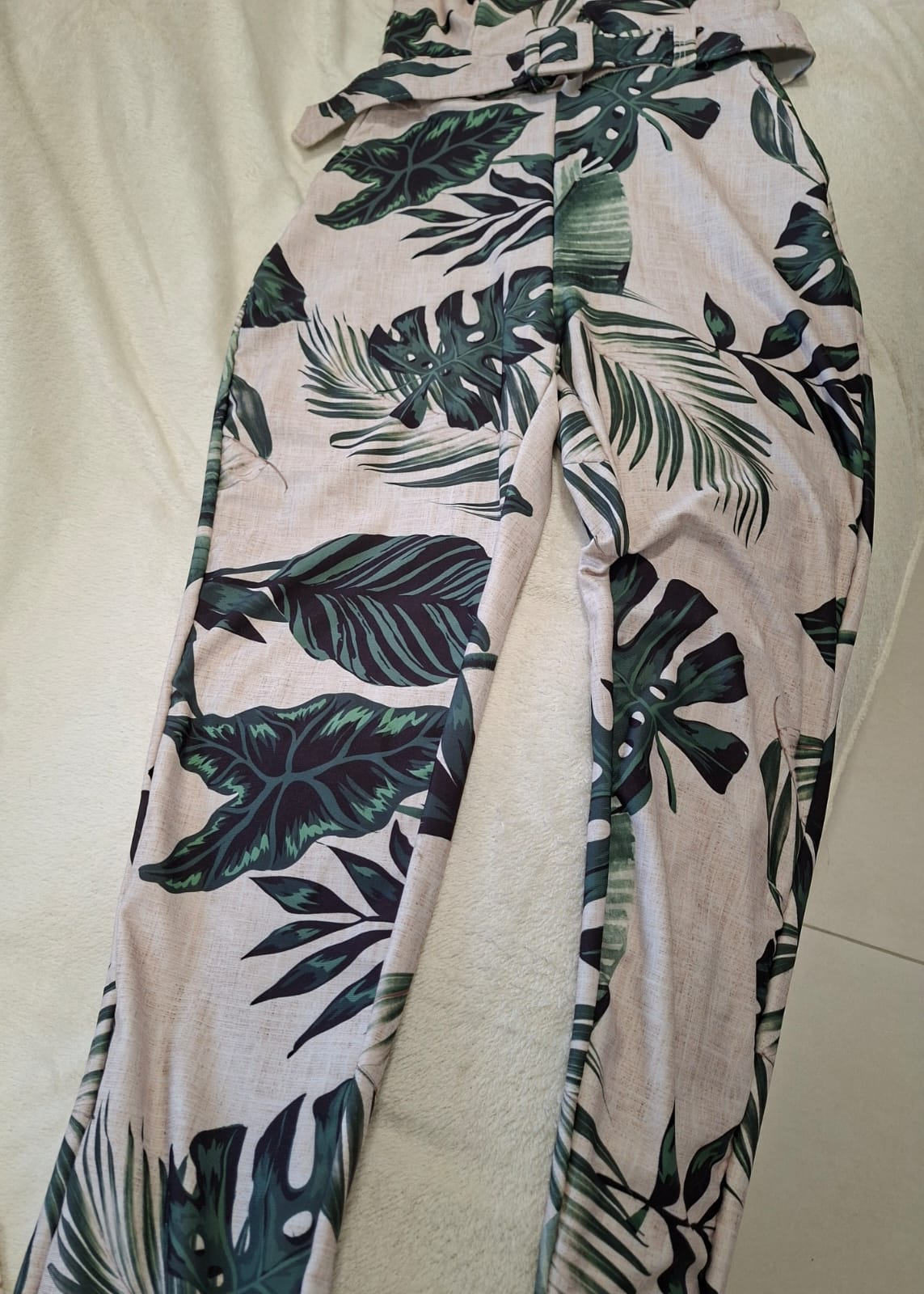 Macacão lindíssimo com fundo creme e estampa de folhas, veste um tamanho P/M
